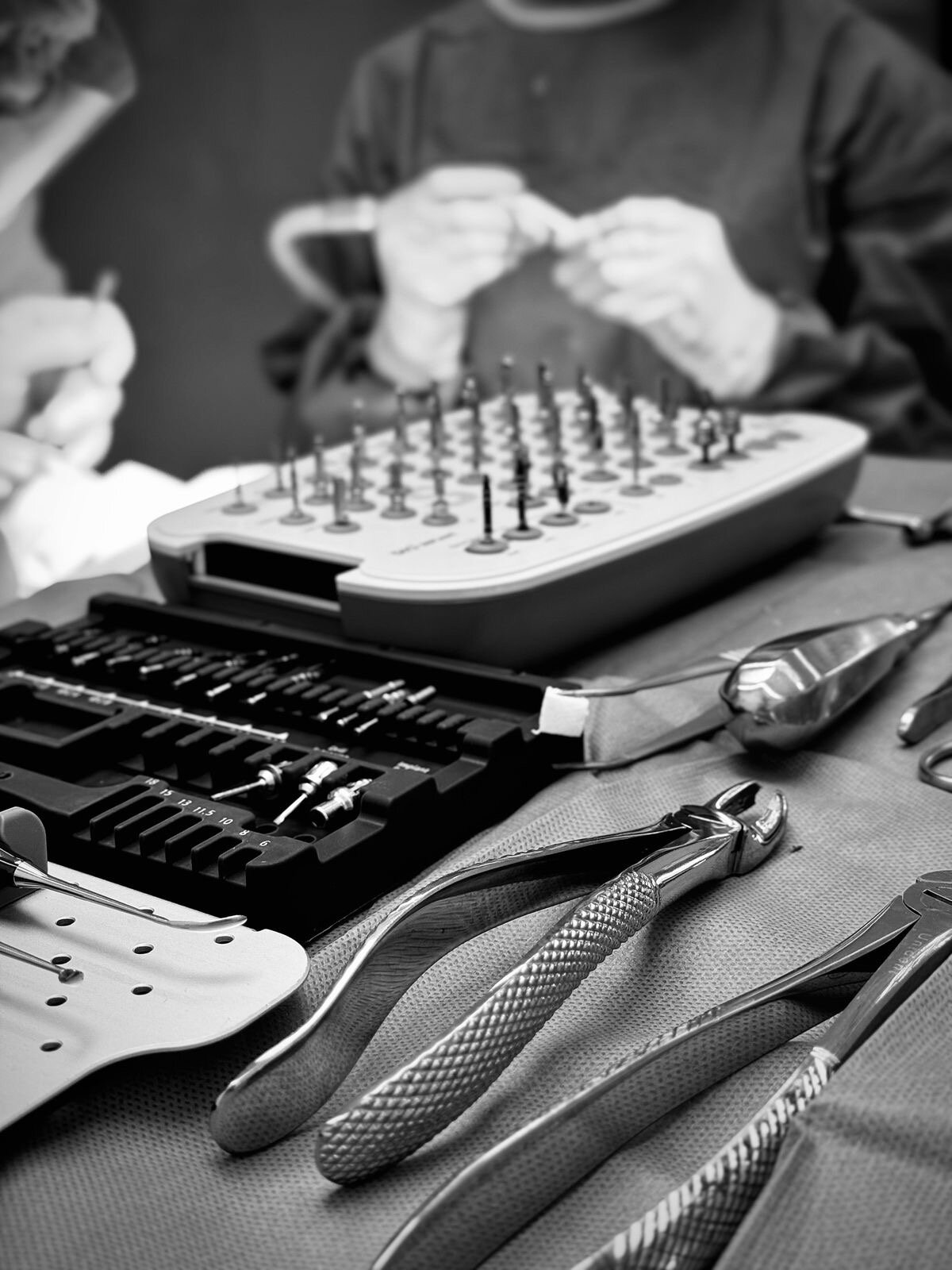 Instrumenti za precizan rad u dentalnoj kirurgiji Dentalni instrumenti na stolu i osoblje u pozadini